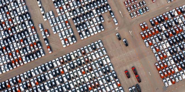 birds eye view of many cars parked aligned in a storage park