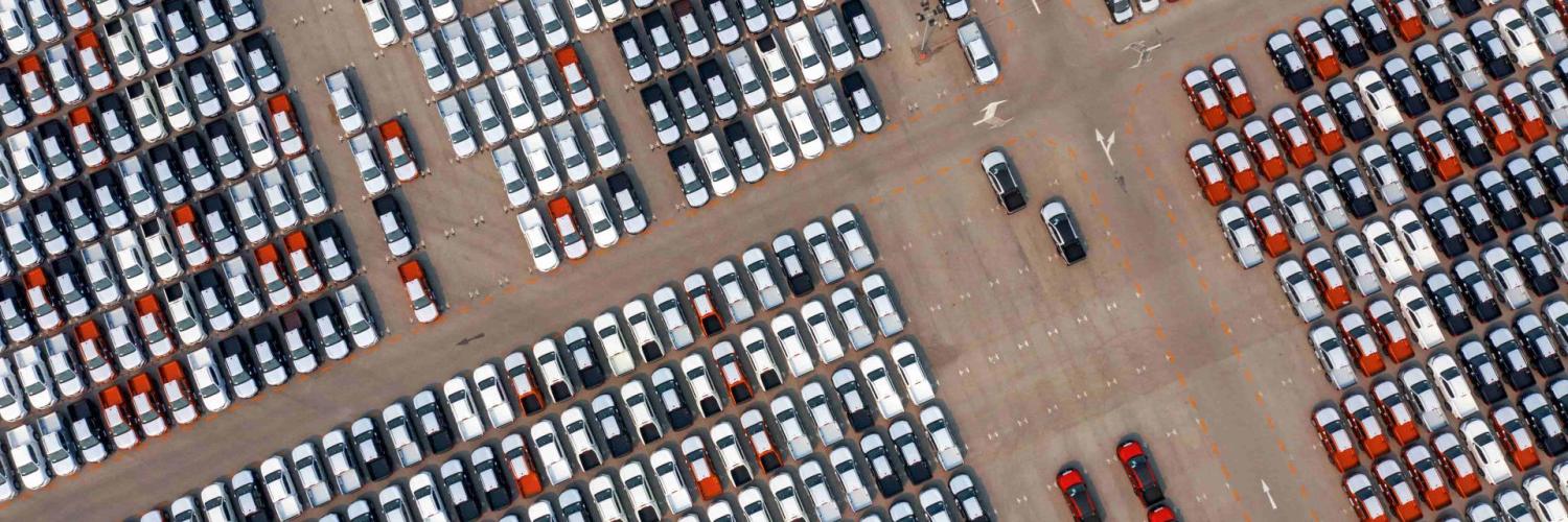 birds eye view of many cars parked aligned in a storage park