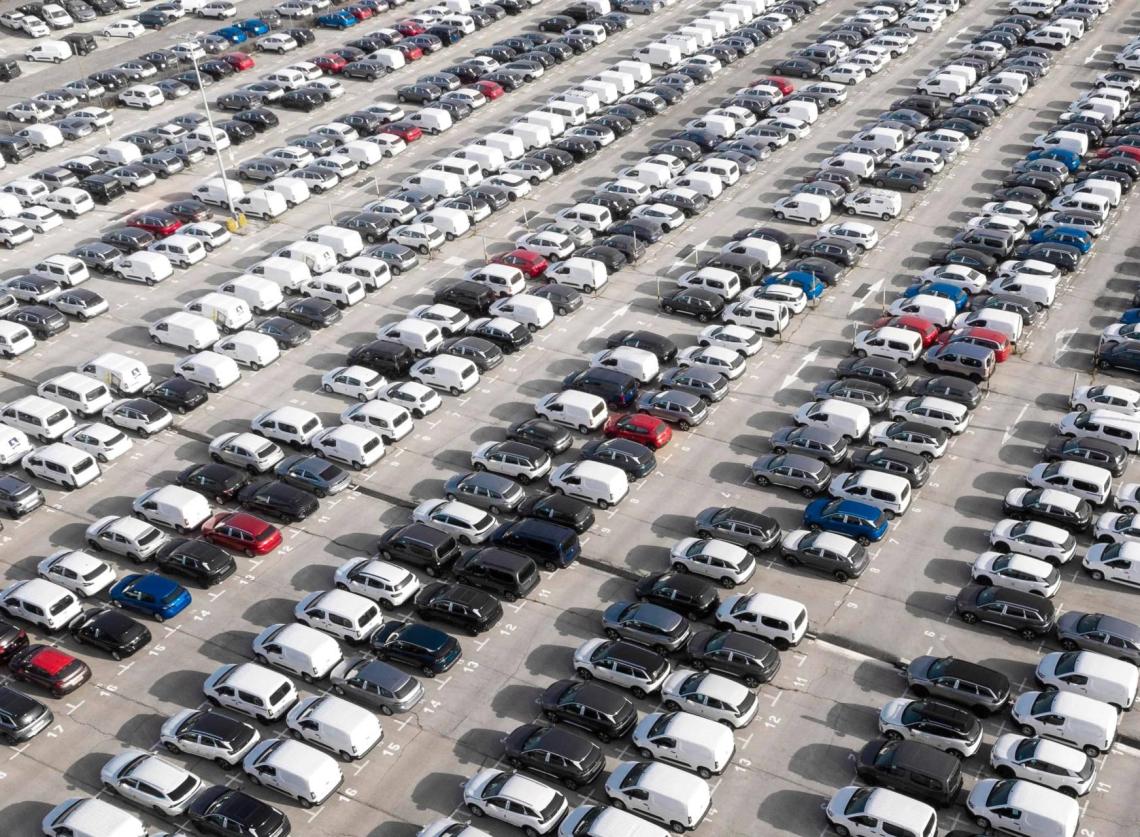 A view from the sky of many vehicles parked in a storage park